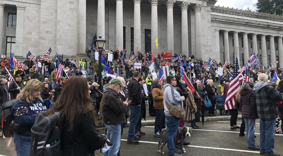 Photo of a group of protestors standing in front of the State Capitol Building in Olympia, WA