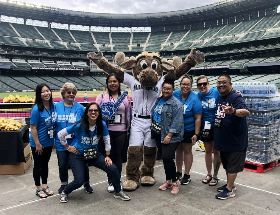 WSCADV staff and board standing with the Mariners moose and smiling at T-Mobile Park