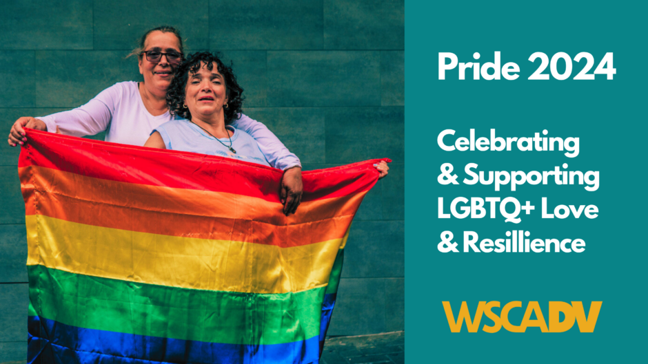 Two women in their fifties stand smiling together and holding a rainbow flag. Text is below.