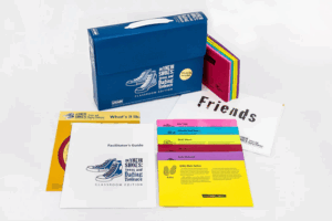 Picture of the In Their Shoes Teens and Dating Violence Training Kit. The picture shows some pieces from the kit laid out on a table including multicolored cards, an instruction booklet, and a station label.
